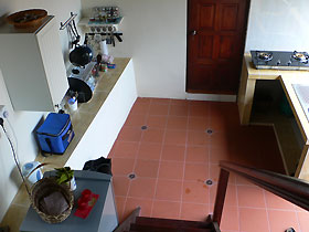 kitchen seen from top of stairs and bathroom beyond that
