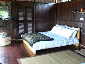 double bed with duvet and mosquito vape at hand